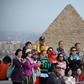 Tourists pose for a group picture at the Giza pyramids on the southwestern outskirts of the Egyptian capital Cairo on December 29, 2018