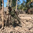 File picture shows Mozambique soldier looking at a burned village structure in the north of the country where over the past year, hardline Islamists have been active