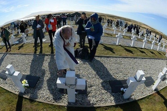 A priest blesses the grave of an Argentine soldier killed during the 1982 war between Argentina and Britain, at a military cemetery in the Falkland Islands, known in Spanish as the Malvinas