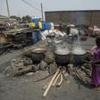 Cauldrons pf the traditional sorghum-based pito drink bubble away in fire pits in Tema, Accra