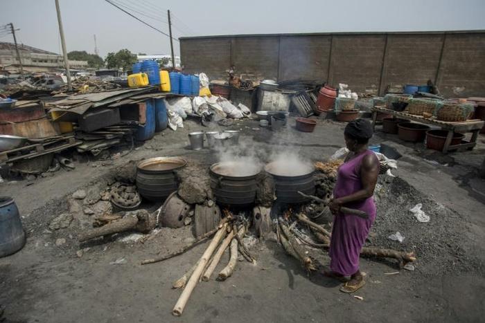 Cauldrons pf the traditional sorghum-based pito drink bubble away in fire pits in Tema, Accra
