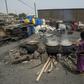 Cauldrons pf the traditional sorghum-based pito drink bubble away in fire pits in Tema, Accra