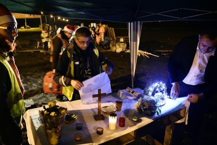 Father Joseph Nurchi prepares for a Christmas Eve mass at a roundabout in Somain, northern France, where "yellow vest" protesters have been holding out since November