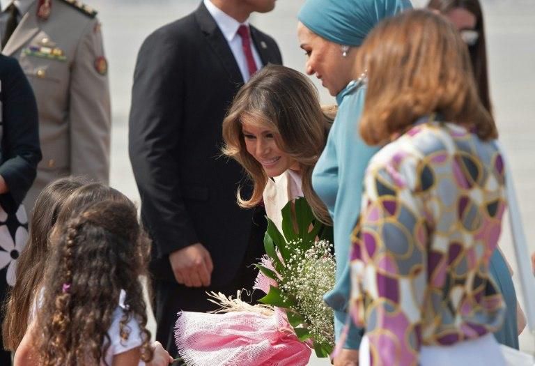 A beaming US First Lady Melania Trump greets flower girls at Cairo International Airport flanked by her Egyptian counterpart Intissar Amer al-Sisi
