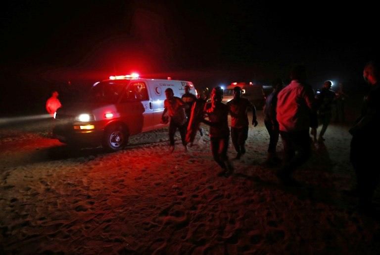 Palestinian paramedics rush from an ambulance during a protest near the Israeli border east of Rafah in the southern Gaza Strip, on September 26, 2018