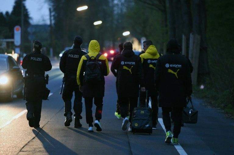 Police escort Dortmund's players after their team bus was caught in a bomb blast April 11, 2017