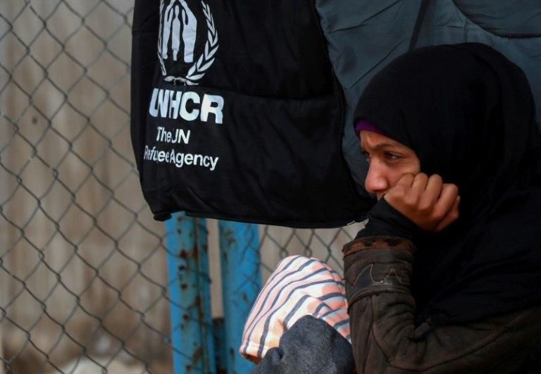 A Syrian displaced girl sits by a fence inside the Al-Hol IDP camp in northeast Syria