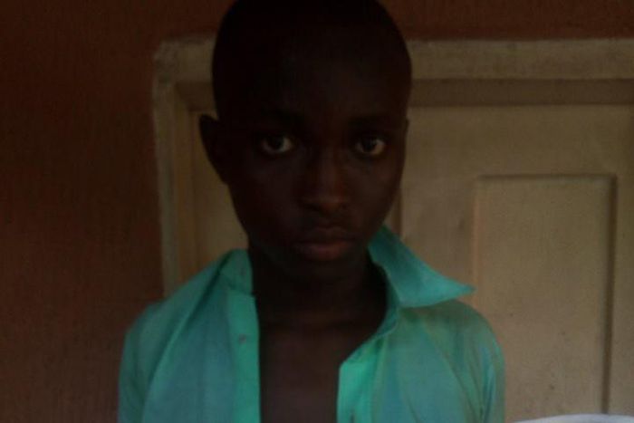 A student holds out a white with blood stains. He reportedly bled into it after receiving mighty whips in school.