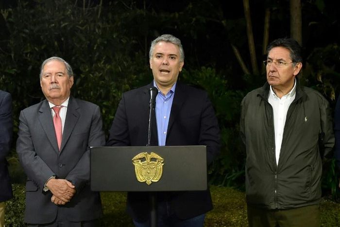 Colombian President Ivan Duque (C) speaks next to Colombian Defense Minister Guillermo Botero (L) and Colombian Attorney General Nestor Humberto Martinez (R) at the Narino presidential palace in Bogota on December 21, 2018