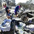 Katherine Marinara and her son Luca sift through the remains of their home in Malibu, California
