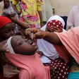 A Nigerian health official administers a polio vaccine to a child in Kano, northern Nigeria.