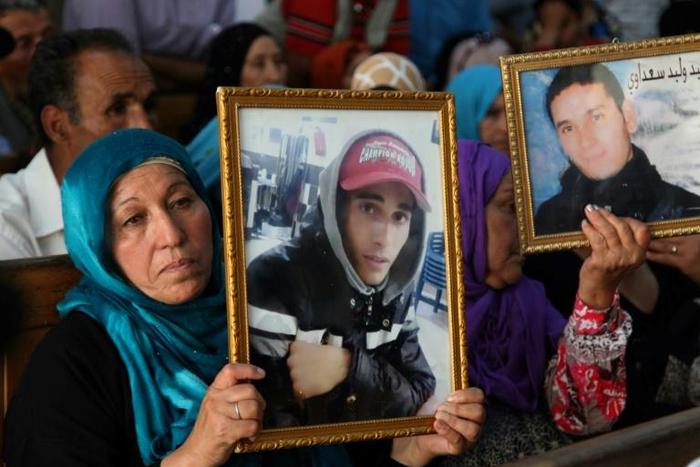 Families of victims of Tunisia's 2011 revolt against dictatorship carry portraits of their loved ones during a trial in Kasserine on July 13, 2018