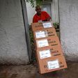 A worker at the Regional Electoral Court Storage in Jardim Botanico neighborhood, Rio de Janeiro, carries electronic ballots for distribution during preparations on the eve of Brazil's general election