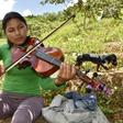 Mariel Chura, 21, plays the viola during a break from the coca harvest in Bolivia -- she says music helps her forget her problems