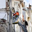 Firemen inspecting buildings near the site where two dilapidated buildings suddenly collapsed this week in the centre of Marseille, southern France