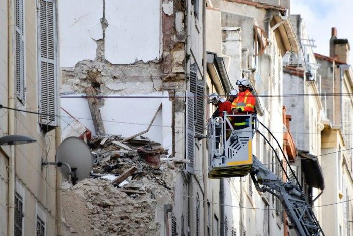 Firemen inspecting buildings near the site where two dilapidated buildings suddenly collapsed this week in the centre of Marseille, southern France
