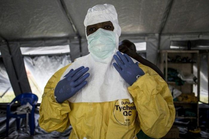 A medical worker puts on his Personal Protective Equipment (PPE) ahead of entering an Ebola Treatment Centre in Beni