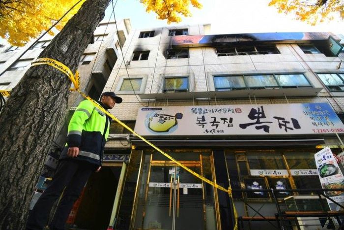A South Korean policeman stands guard outside the scene after a fire that killed at least seven people in Seoul