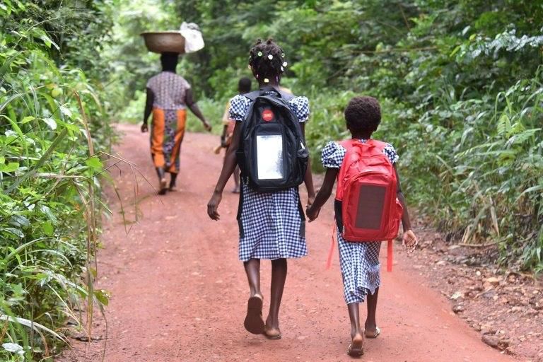 Last year, 13-year-old Lucienne, shown here walking to school with Marie-France, could not go to school at all because their mother was off work with an illness