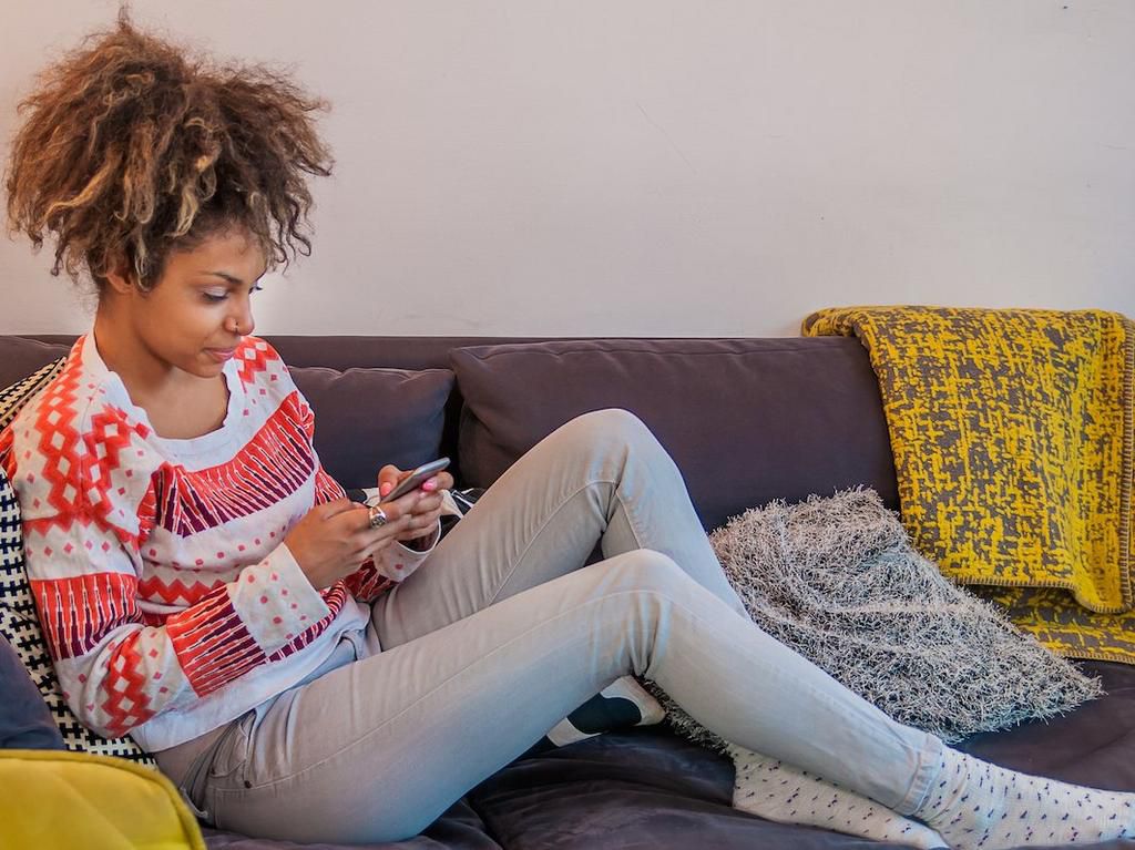 woman texting on couch
