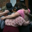 Mourners embrace next to a makeshift memorial to Heather Heyer in Charlottesville, Virginia, on the one year anniversary of her death at the hands of a white supremacist in a speeding car