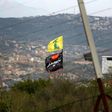 A flag of Lebanon's Hezbollah Shiite movement and a religious flag reading "al-Hussein" fly on the border with Israel