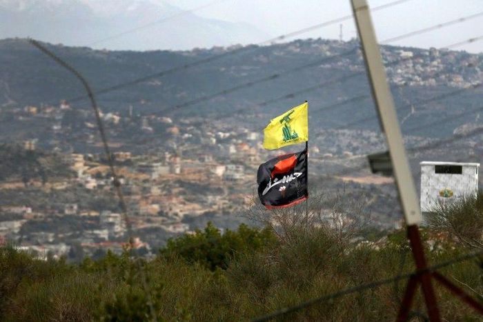 A flag of Lebanon's Hezbollah Shiite movement and a religious flag reading "al-Hussein" fly on the border with Israel