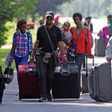Asylum seekers walk down Roxham Road to cross into Quebec at the U.S.-Canada border in 2017