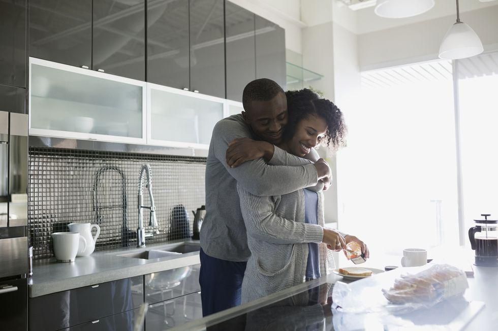 A happy couple in their kitchen, cooking.