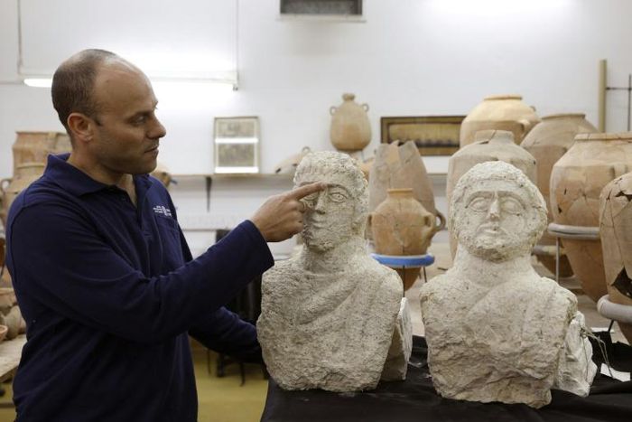 Israeli archaeologist Eitan Klein of the Israel Antiquities Authority shows off two late Roman busts unearthed near the ancient city of Beit Shean following a chance find by a woman walker