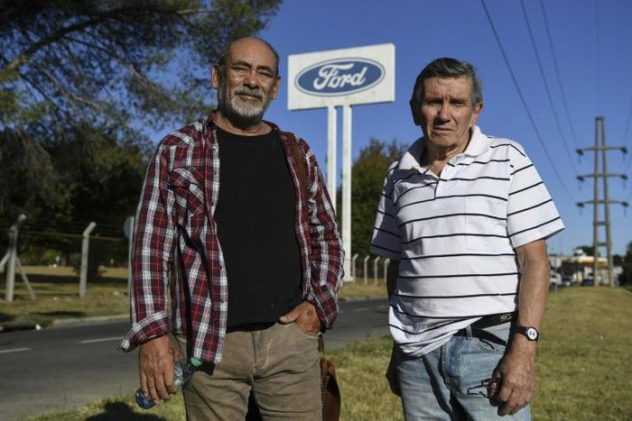 Carlos Propato (L) and Pedro Troiani, former workers of Ford and former political prisoner, pose during an interview with AFP outside Ford’s General Pacheco plant in Buenos Aires on March 16, 2018