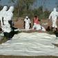 A picture released by Syrian state news agency SANA on December 12, 2018 shows people said to be forensic experts exhuming bodies from a mass grave near the former jihadist stronghold of Albu Kamal