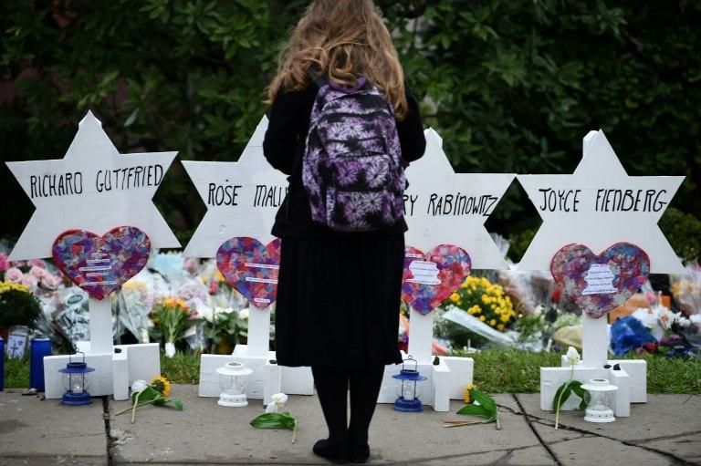 A woman stands at a memorial outside the Tree of Life synagogue after a shooting there left 11 people dead in the Squirrel Hill neighborhood of Pittsburgh on October 27