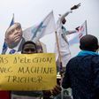 An opposition supporter holds a sign reading "No election with a cheating machine" -- there have been concerns about the use of electronic voting machines in DRC's poll