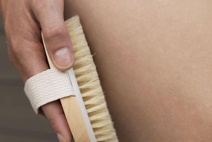 ___9068956___2018___11___4___16___womans-arm-holding-dry-brush-to-top-of-her-leg-royalty-free-image-1009498510-1540306229