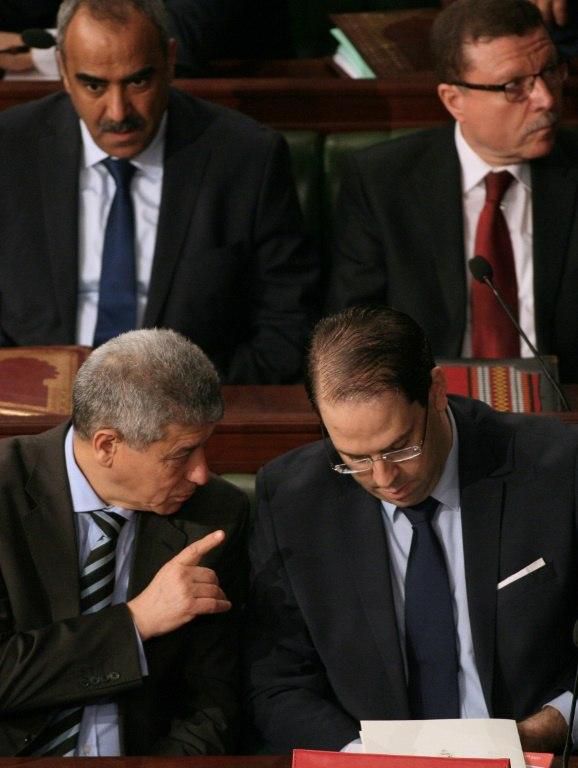 Tunisian Prime Minister Youssef Chahed speaks with Justice Minister Ghazi Jeribi on March 23, 2018 during a session of parliament