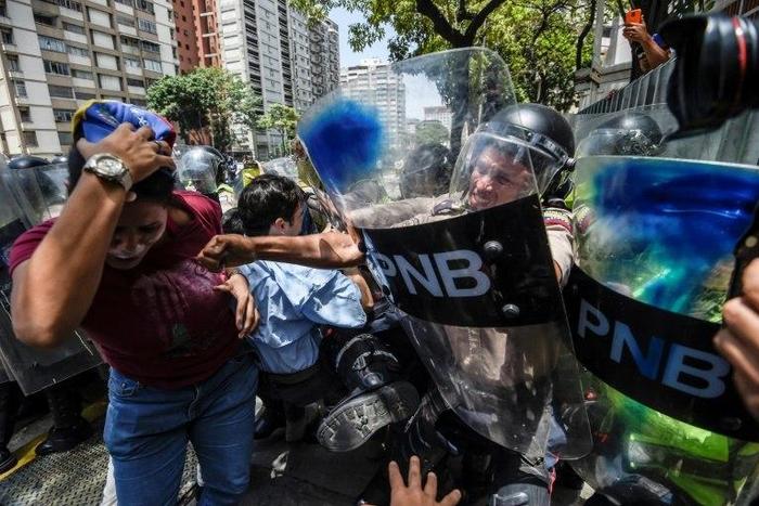 An estimated 1,000 people scuffled with police as they tried to march to Venezuela's National Assembly to demand the government restore powers to its opposition majority