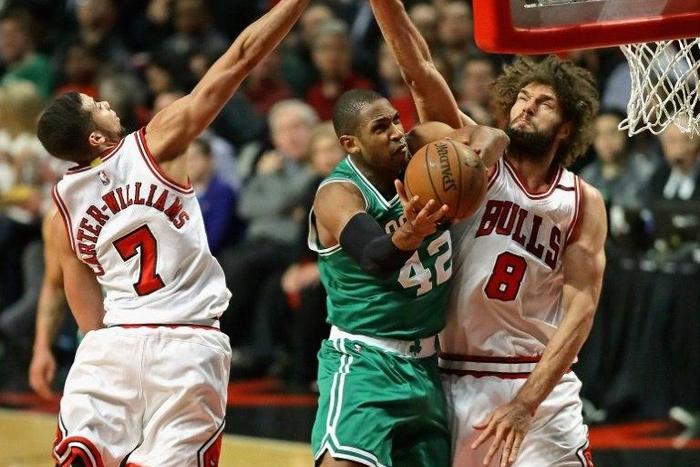 Al Horford of the Boston Celtics puts up a shot between Michael Carter-Williams (L) and Robin Lopez of the Chicago Bulls during Game Three of the Eastern Conference Quarterfinals
