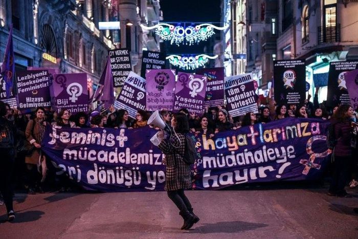People hold signs as they march down Istiklal Avenue during a feminist night march to mark International Women's Day in Istanbul on March 8, 2017