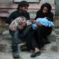 A Syrian couple mourn for one of their children in the rebel-held besieged town of Douma following who died in air strikes on the Eastern Ghouta region on the outskirts of the capital Damascus