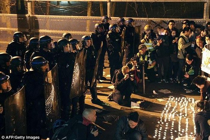 Police face demonstrators during a protest in front of the police headquarters in the 19th arrondissement of Paris on
