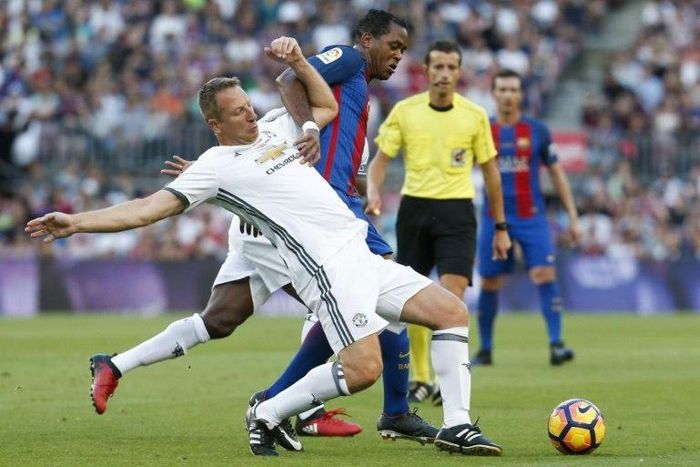 Dutch former Barcelona forward Patrick Kluivert (R) tackles ex-Manchester United defender Lee Martin during a charity match between Barcelona Legends and Man United Legends at the Camp Nou stadium in Barcelona on June 30, 2017
