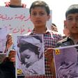 Syrian residents of Khan Sheikhun hold placards and pictures on April 7, 2017 during a protest condemning a suspected chemical weapons attack on their town that killed at least 86 people