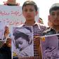 Syrian residents of Khan Sheikhun hold placards and pictures on April 7, 2017 during a protest condemning a suspected chemical weapons attack on their town that killed at least 86 people
