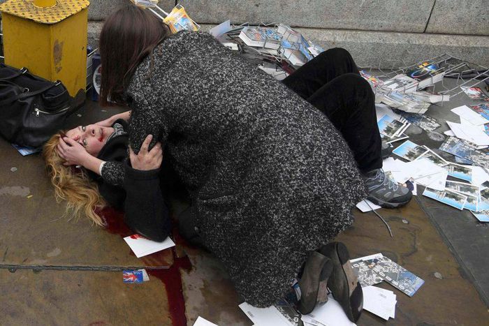 A woman helps a victim of the terror attack which a car plough down pedestrians on London Bridge on Saturday, June 3, 2017.