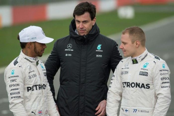 Mercedes drivers Britain's Lewis Hamilton (L) and Finland's Valtteri Bottas (R) pose with team chief Toto Wolff by the new 2017 season car at its launch at Silverstone near Towcester, central England on February 23, 2017
