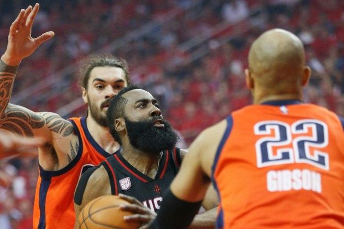James Harden (C) of the Houston Rockets drives to the basket past the Oklahoma City Thunder players during the 2017 NBA playoffs' first round, in Houston, Texas, on April 16, 2017