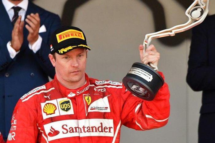 Ferrari's Finnish driver Kimi Raikkonen holds his trophy as he celebrates on the podium after the Monaco Formula 1 Grand Prix at the Monaco street circuit, on May 28, 2017