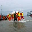 Hundreds of people gathered solemnly on a beach in southern Myanmar awaiting news of their loved ones as rescuers worked to pull bodies from the Andaman Sea after a military plane crashed with more than 120 people on board