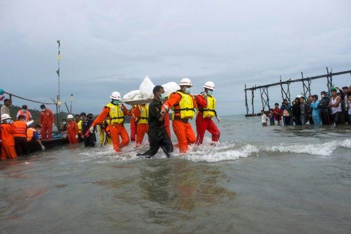 Hundreds of people gathered solemnly on a beach in southern Myanmar awaiting news of their loved ones as rescuers worked to pull bodies from the Andaman Sea after a military plane crashed with more than 120 people on board